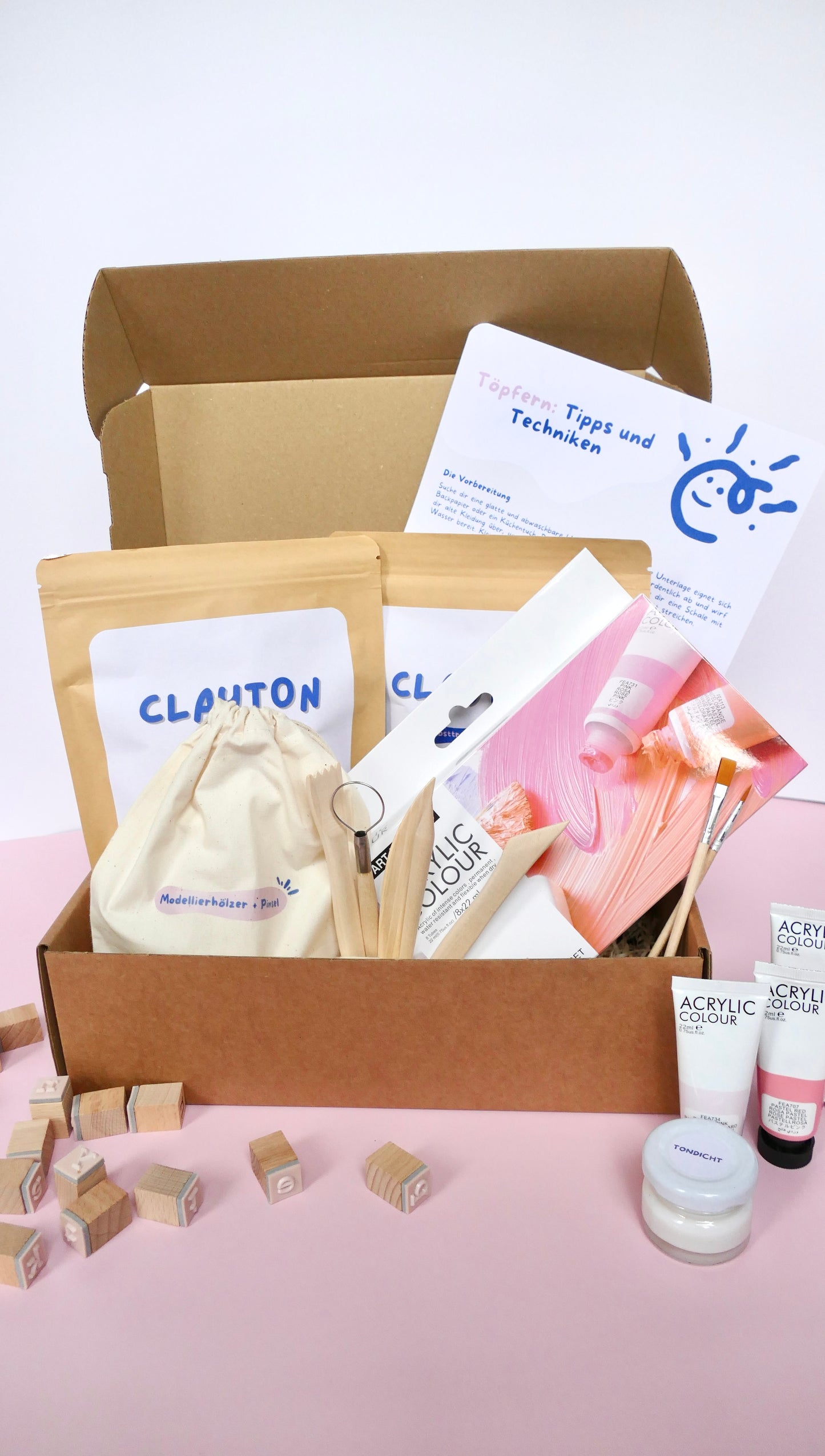 Töpferset für zuhause ohne Brennofen in Geschenkbox. Enthalten sind 2 Packungen des selbsttrocknenden Ton, 5 Modellierhölzer fürs Modellieren beim Töpfern, 2 Pinsel, 8 Pastell-Acrylfarben, Grundierung, eine Töpferanleitung für Anfänger und Tonstempel
