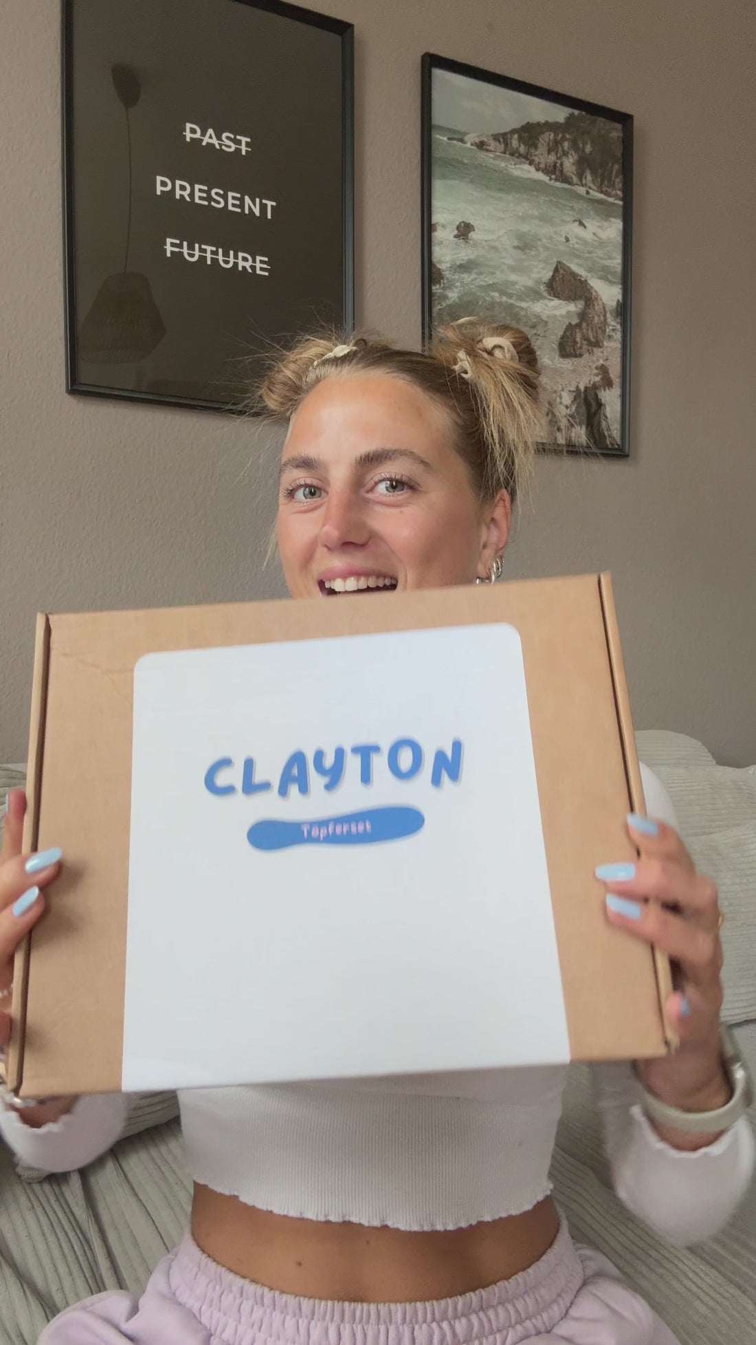Frau hält eine Box mit der Aufschrift Töpferset in der Hand. 